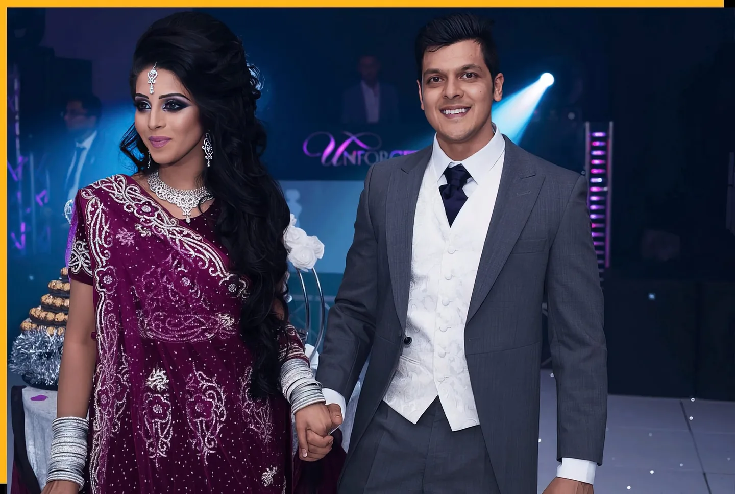 Wedding couple holding hands at their reception, wearing purple and grey