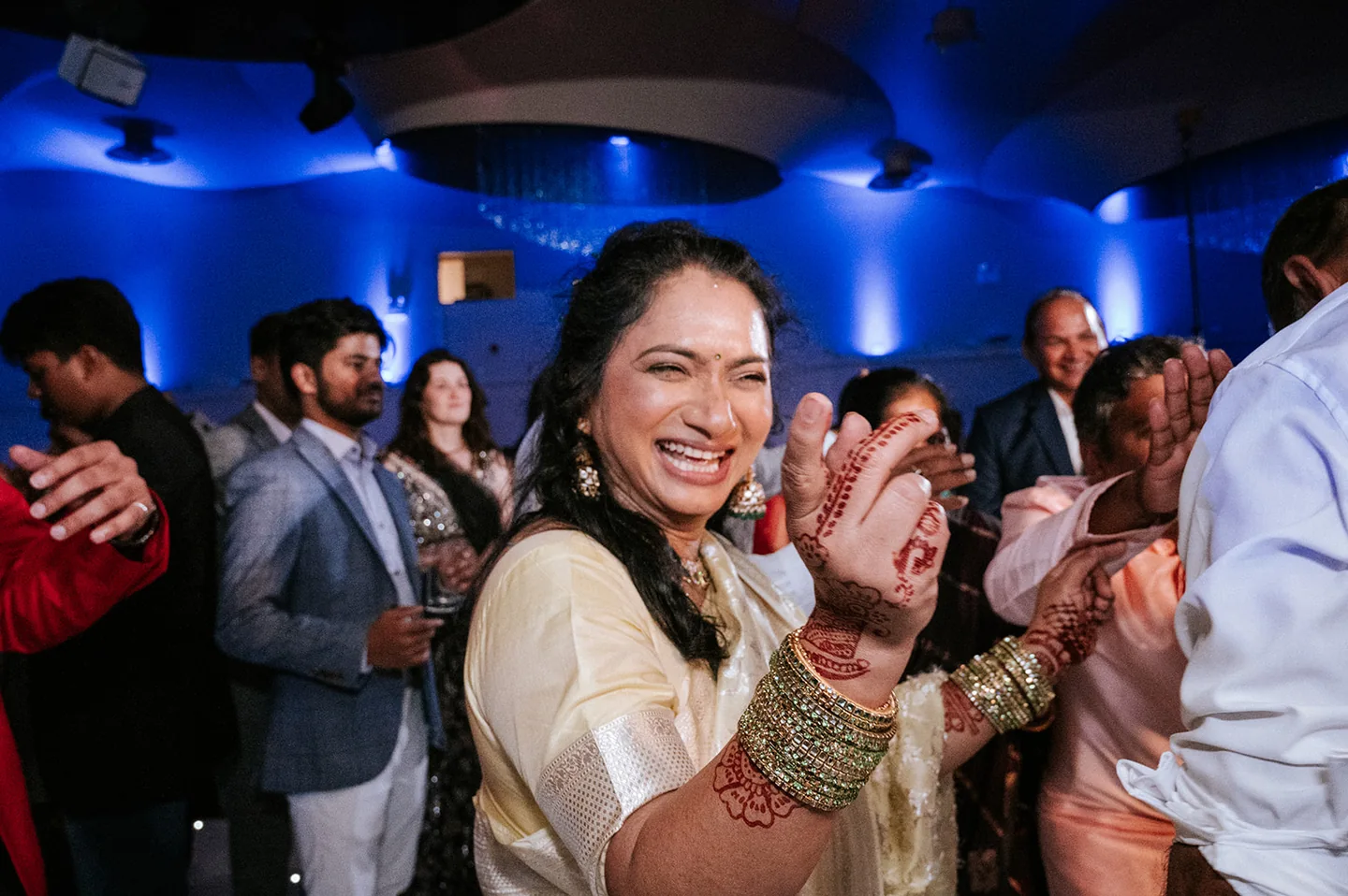 Wedding guest laughing and dancing, with decorated hands raised