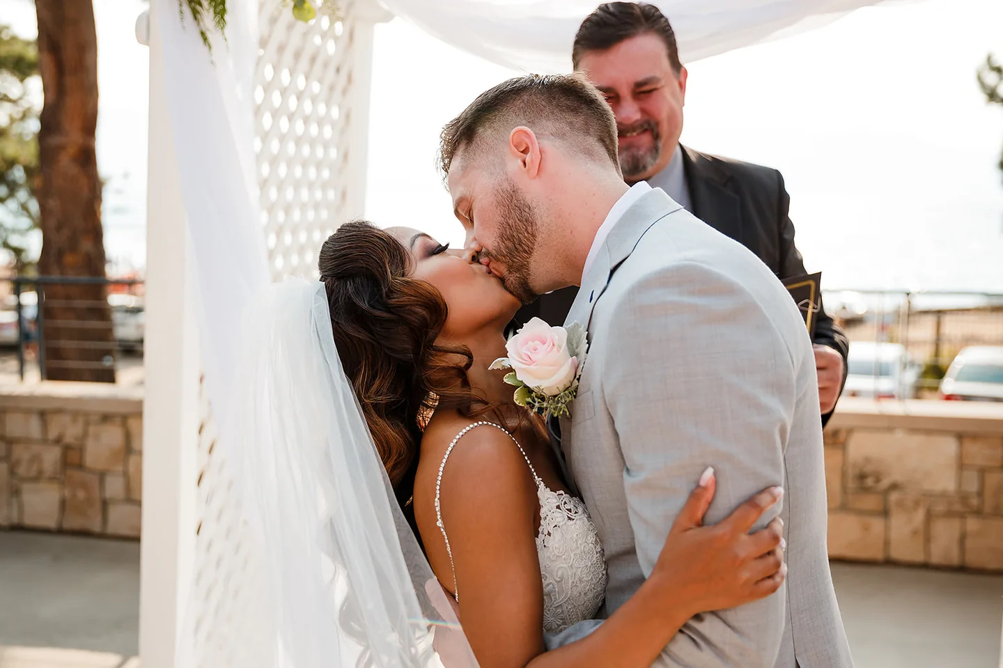 Bride and groom sharing a kiss during an outdoor wedding ceremony