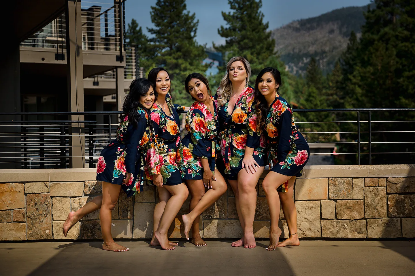 Bridesmaids posing together outdoors in matching floral robes