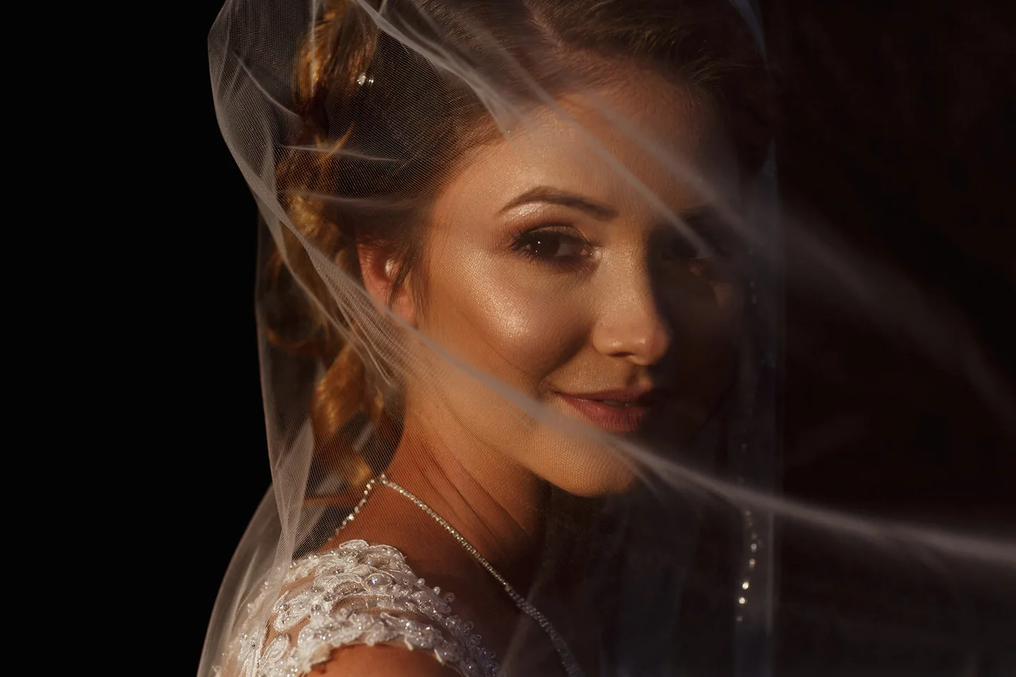 Close bridal portrait with a softly draped veil across her face