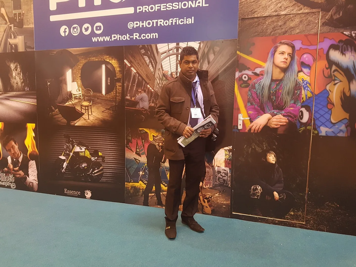 Davinder at a photography exhibition, standing beside a display of photographs